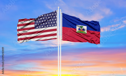 Φωτογραφία Haiti and United States flag waving in the wind against white cloudy blue sky together