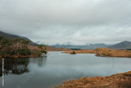 Connemara National Park in Ireland. Scenic drive on N59 route stretches beside the calm ocean water surrounded by mountains. Ireland