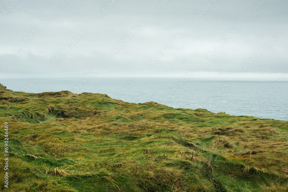 Foggy view of famous Cliffs of Moher and wild Atlantic Ocean, County Clare, Ireland.