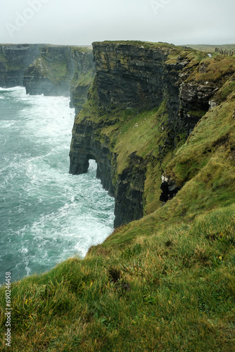 Foggy view of famous Cliffs of Moher and wild Atlantic Ocean, County Clare, Ireland.