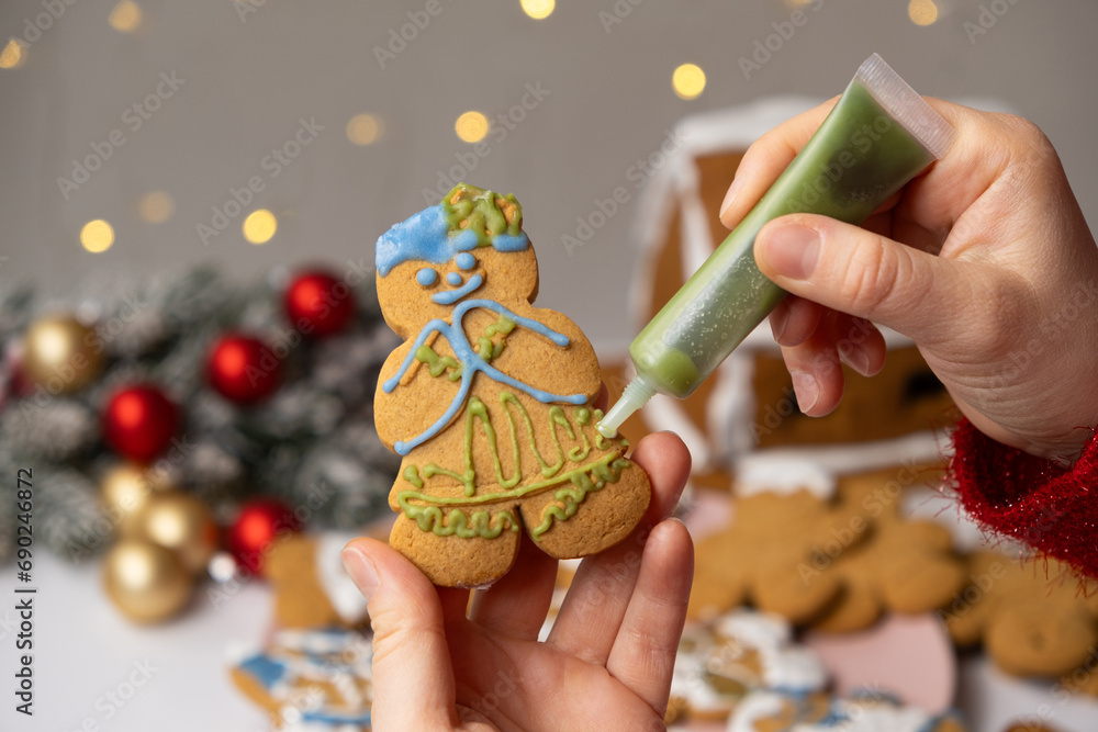 Fototapeta premium Decorating Christmas gingerbread with sugar multicolored icing.