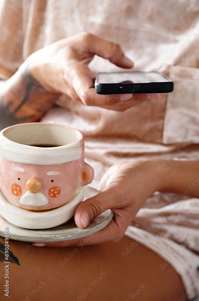 Woman drinking tea and texting on smartphone. Cozy winter weekend morning. Woman drinking tea and texting on smartphone. Cozy winter weekend morning.