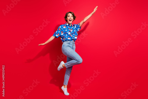 Full body photo of flying young girl raised arms up promo banner preparation shopping mall sale xmas party isolated on red color background