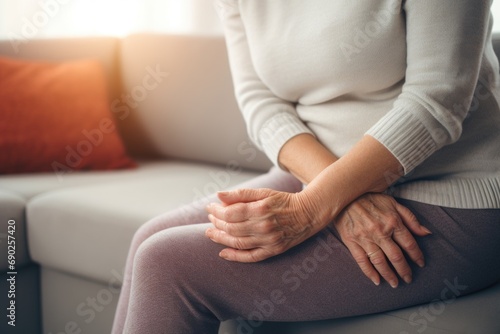 A woman is sitting on a couch  holding her hands. This image can be used to depict relaxation  meditation  or contemplation