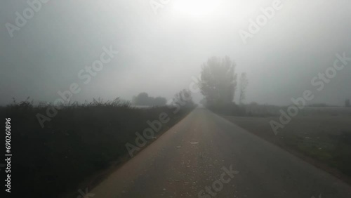 Pov of Driver driving on dangerous slippery foggy road with low visibility photo
