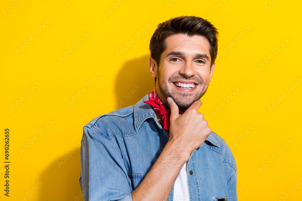 Photo portrait of attractive young man touch chin thinking dressed stylish denim clothes isolated on yellow color background Photo portrait of attractive young man touch chin thinking dressed stylish denim clothes isolated on yellow color background