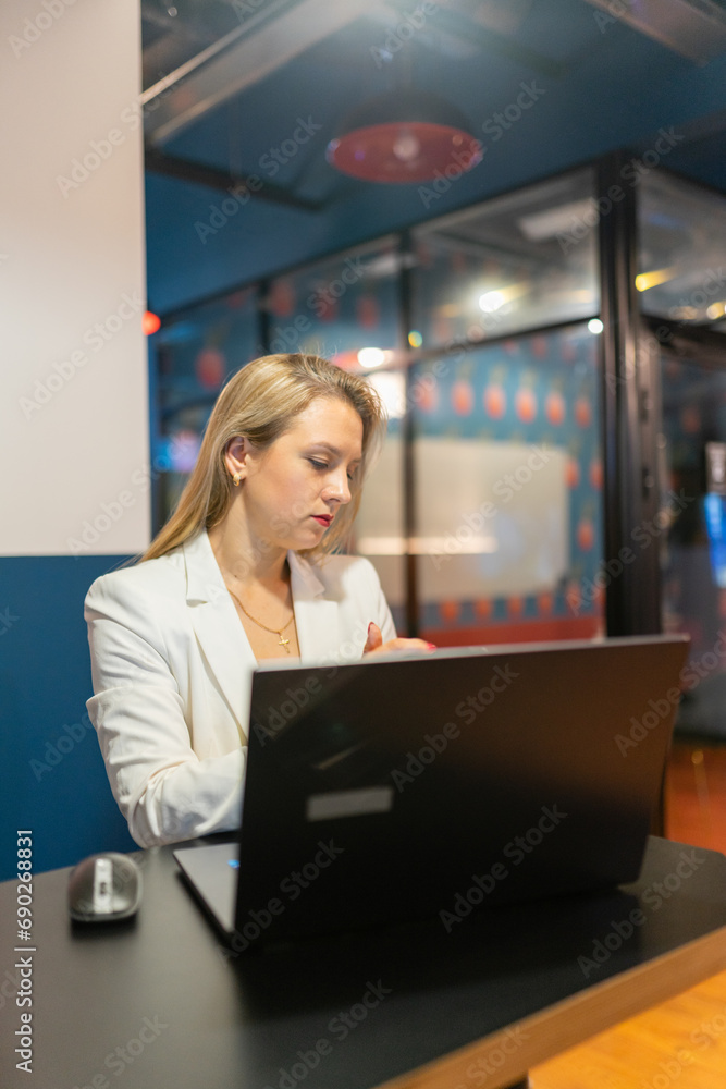 Obraz premium Woman in classic clothes sits at laptop with open screen immersed in work. Contemporary workplace creates pleasant working atmosphere