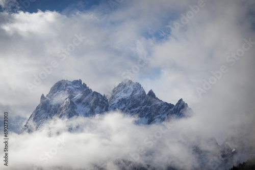 Snow covered peaks of the Sesto Dolomites with clouds in winter, mountains of the Alps, South Tyrol, Italy, Europe