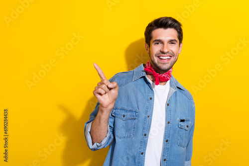 Photo portrait of nice young man point cheerful empty space dressed stylish denim garment isolated on yellow color background