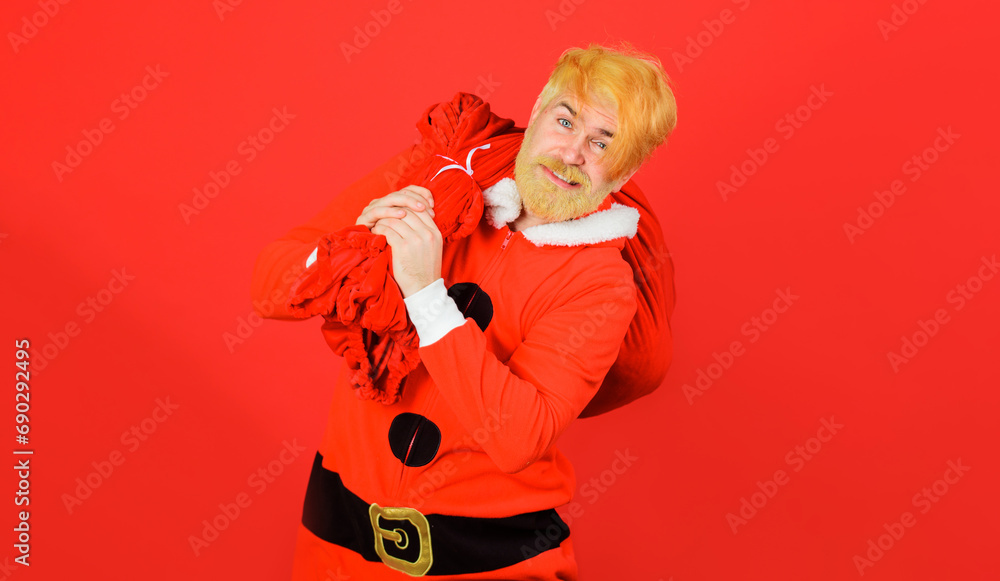 Christmas eve. Santa Claus holds large sack with Christmas presents to children. Delivery gift. Bearded man in Santa Claus costume carrying big bag full of New Year gifts. Winter holidays celebration. Christmas eve. Santa Claus holds large sack with Christmas presents to children. Delivery gift. Bearded man in Santa Claus costume carrying big bag full of New Year gifts. Winter holidays celebration.