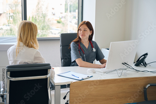 Photos Doctor entering patient data into electronic health record during consultation
