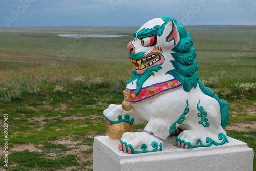 Canvastavla Sculpture of a Buddhist lion guard against the background of the Kalmyk steppe o