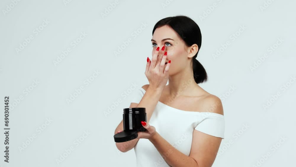 Portrait of a charismatic young woman using face creams. Concept of fresh moisturized skin, beautiful cosmetic face, happy healthy model. A young brunette takes care of her skin. Portrait of a charismatic young woman using face creams. Concept of fresh moisturized skin, beautiful cosmetic face, happy healthy model. A young brunette takes care of her skin.