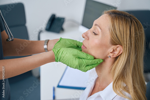 Adult female being examined by ENT doctor photo