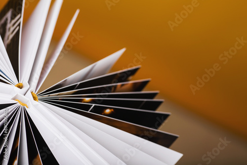 Detail of pages of photoalbum with hard fabric cover on yellow background. Wedding/Family photo album with openwork stamping. Memory book. Family photos archive saved in brightly designed photo book.