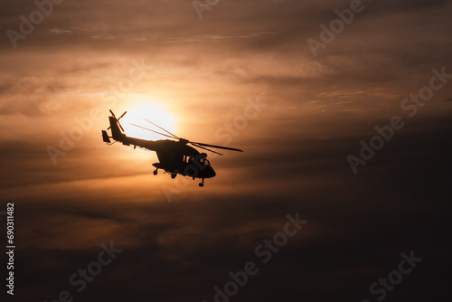 Indian Navy Helicopter flying off into setting sun photo