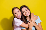 Photo of cheerful impressed small siblings dressed t-shirts having fun embracing empty space isolated yellow color background
