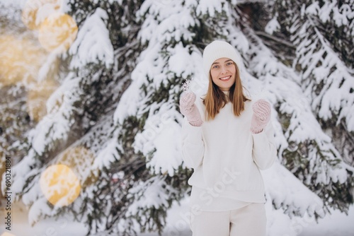 Happy woman in knitted white clothes holding snowflakes