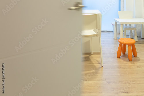 Vista a medias de una sala de un consultorio sanitario infantil con mesas y sillas infantiles photo