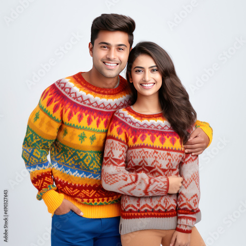 Young couple in warm wear standing on white background.