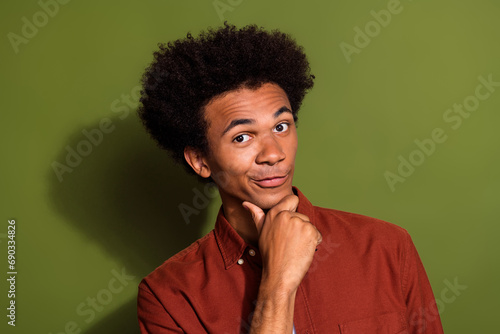 Photo of funny clever man with afro hairstyle dressed brown shirt hand on chin think business ideas isolated on khaki color background