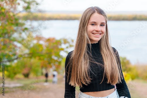 Charming young girl on the background of a river in an autumn forest © KseniaJoyg