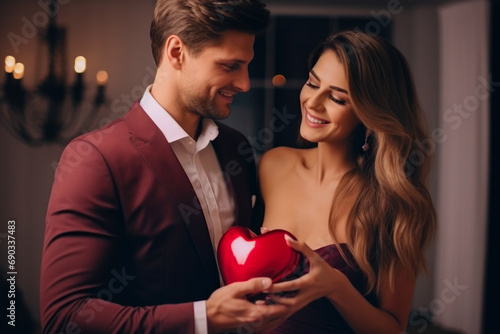 Caucasian couple on Valentine's day. Woman and man give heart to each other. Showing love and affection. Celebration love in modern hotel room.