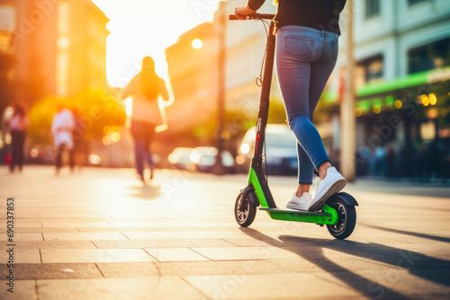 Woman on green scooter in with blurred city background. Young female riding an electric scooter to work, home, school, traveling. © VisualProduction