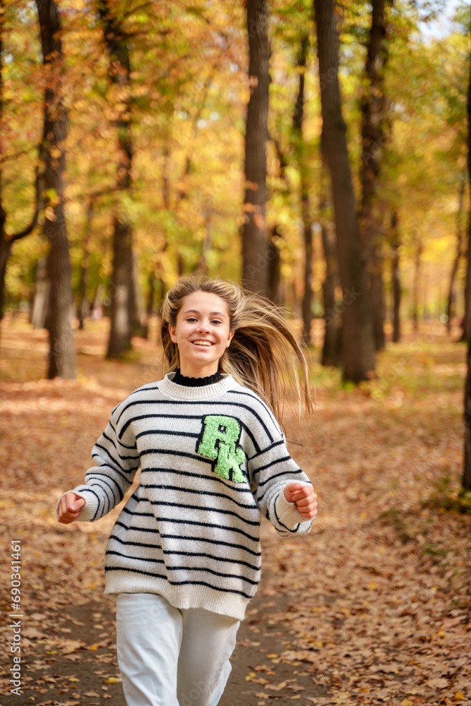 A beautiful teenage girl with long hair smiles and runs in an autumn park. Togliatti, Russia - 30 Sep 2023 A beautiful teenage girl with long hair smiles and runs in an autumn park. Togliatti, Russia - 30 Sep 2023