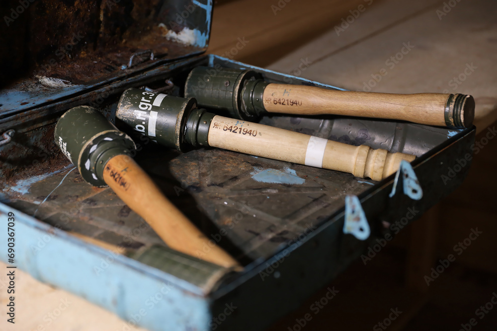 World War II german fragmentation grenades stacked in a military box on wooden table in dark interior World War II german fragmentation grenades stacked in a military box on wooden table in dark interior