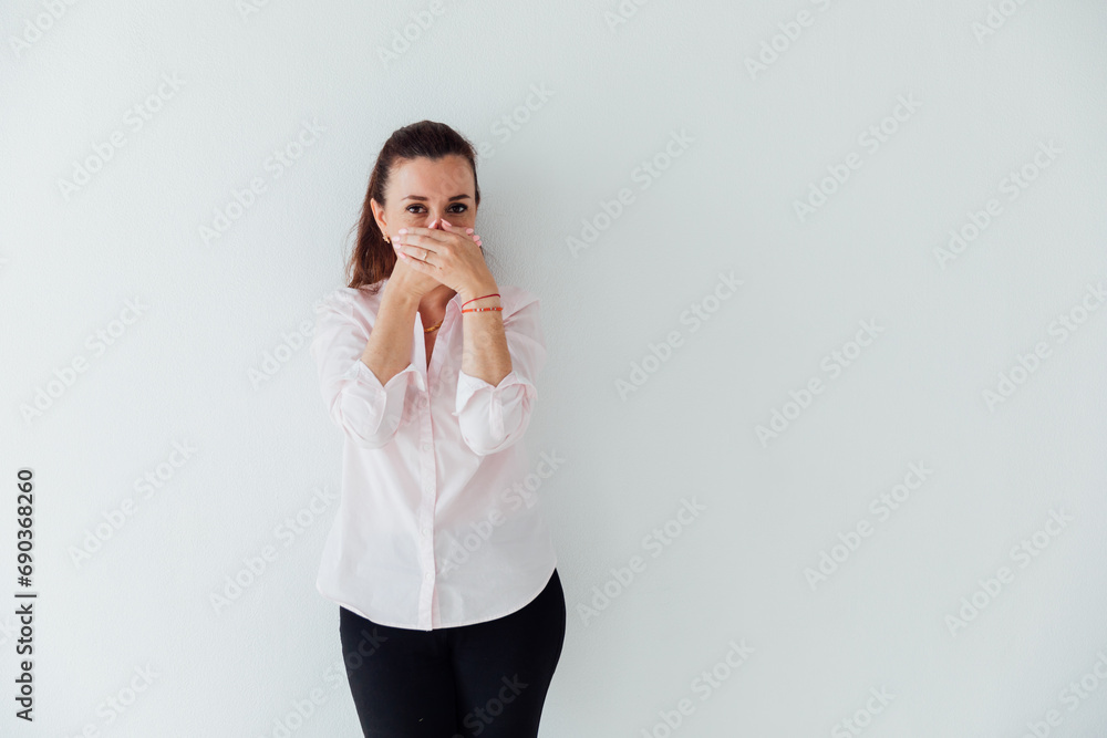 Beautiful brunette woman covers her mouth with her hands Beautiful brunette woman covers her mouth with her hands
