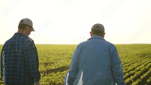 Agriculture. two male farmers walk through farmer field sunset. business meeting two entrepreneurs. two agronomists sunset. team farmers agronomists discuss harvest. organic vegetables. fresh sprouts © DREAM INSPIRATION