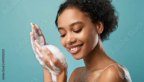 Woman portrait on the blue background, Hands in soap foam.  photo
