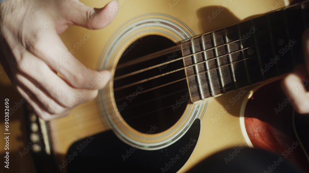 Fototapeta premium Close-up of man playing acoustic guitar with right hand