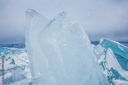 Crystal clear transparent ice pieces on frozen Baikal lake in winter day. 