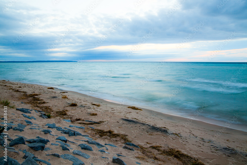 Obraz premium Serene Sunrise Over Lake Michigan's Rocky Blurred Beachscape