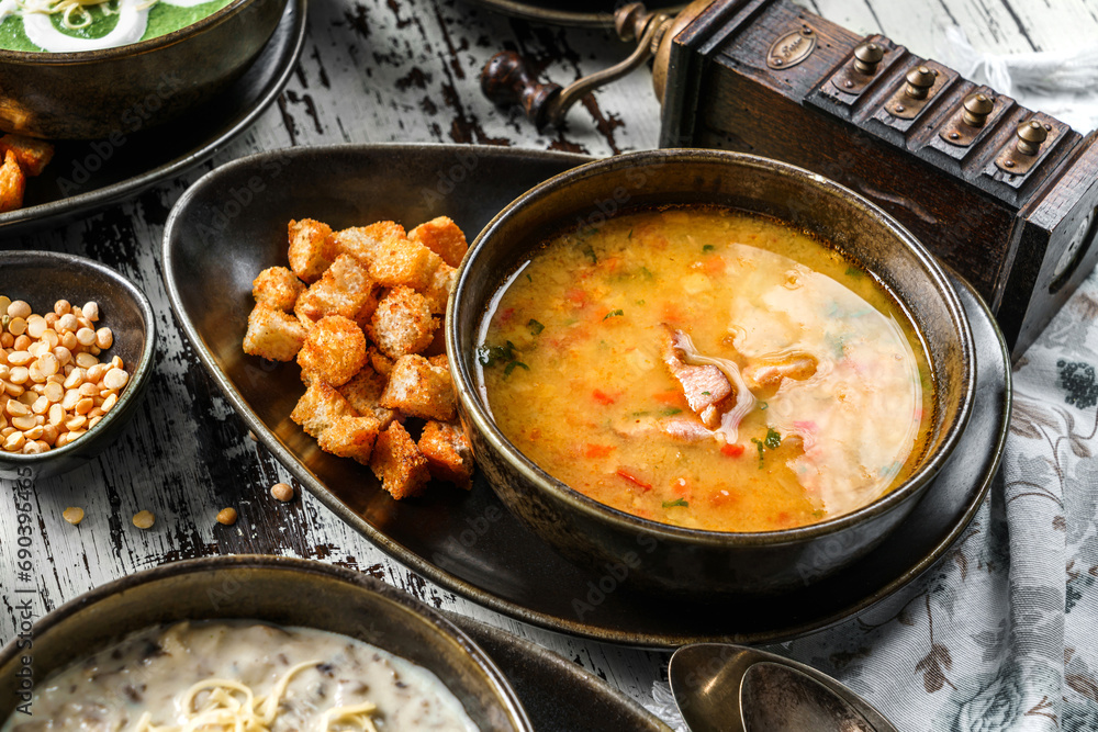 Vegetables soup with bacon, spices and croutons in bowl on rustic wooden background. Healthy food, top view Vegetables soup with bacon, spices and croutons in bowl on rustic wooden background. Healthy food, top view
