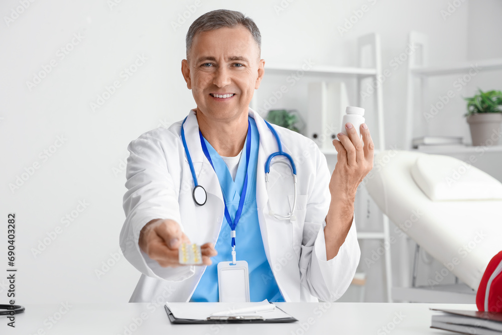 Mature doctor with pills video chatting at table in office Mature doctor with pills video chatting at table in office