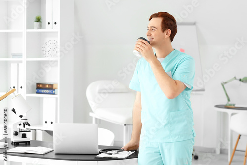 Male doctor drinking coffee in clinic