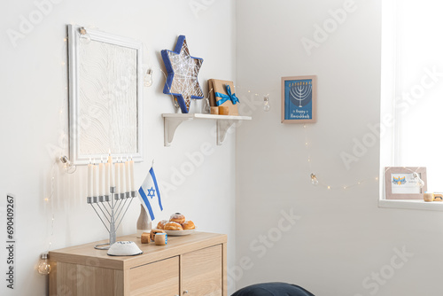 Wooden cabinet with traditional Hanukkah decorations in festive living room © Pixel-Shot