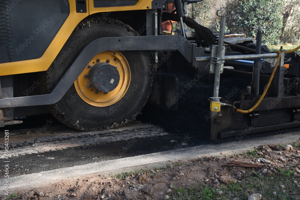 Machine paving a road