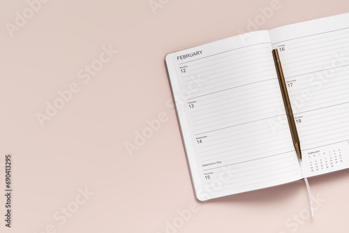 Fotografie open planner with February 14 date open on it and a pen, top view