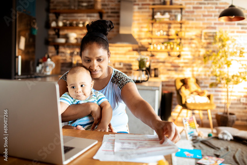 Mother working in home office with baby photo