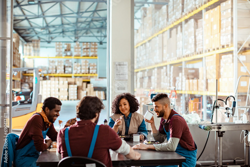 Diverse warehouse workers eating together photo