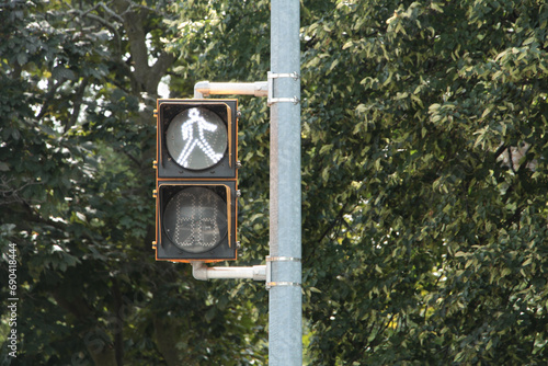 crosswalk walk walking white symbol traffic light direction of person digital electric electonic yellow black on post road street, close up left frame photo