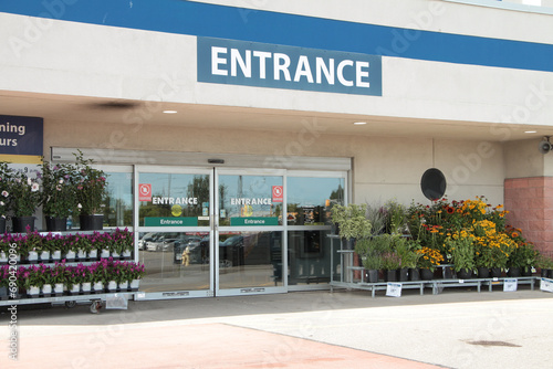 entrance writing caption text facade sign word in white on blue outside exterior outdoors with automatic glass entrance doors beneath