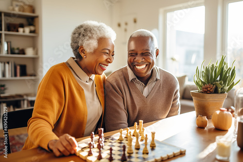 Beautiful loving couple in a retirement home. Senior man and a senior lady playing table game in a nursing home. Housing facility intended for the elderly people.