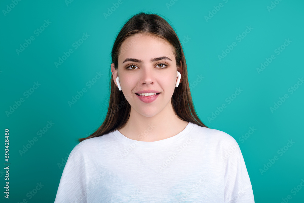 Fototapeta premium Woman listening to music with earphones. Girl with headphones, wireless earphones. Listening music in earphone, studio. Earphones in ear. Woman using headphones. Ear buds, wireless earbud earphone.