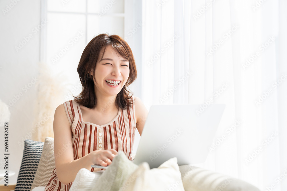 部屋でラップトップコンピューターを見る女性 部屋でラップトップコンピューターを見る女性