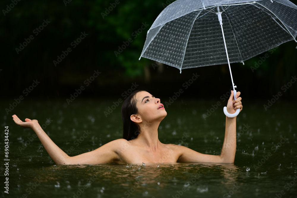 Sexy naked Woman with umbrella in water. Summer rain. Rainy weather